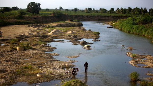 Men bathe in a branch of the Artibonite River outside Saint-Marc. Haiti’s cholera outbreak in 2010 began about 60 miles upstream from here